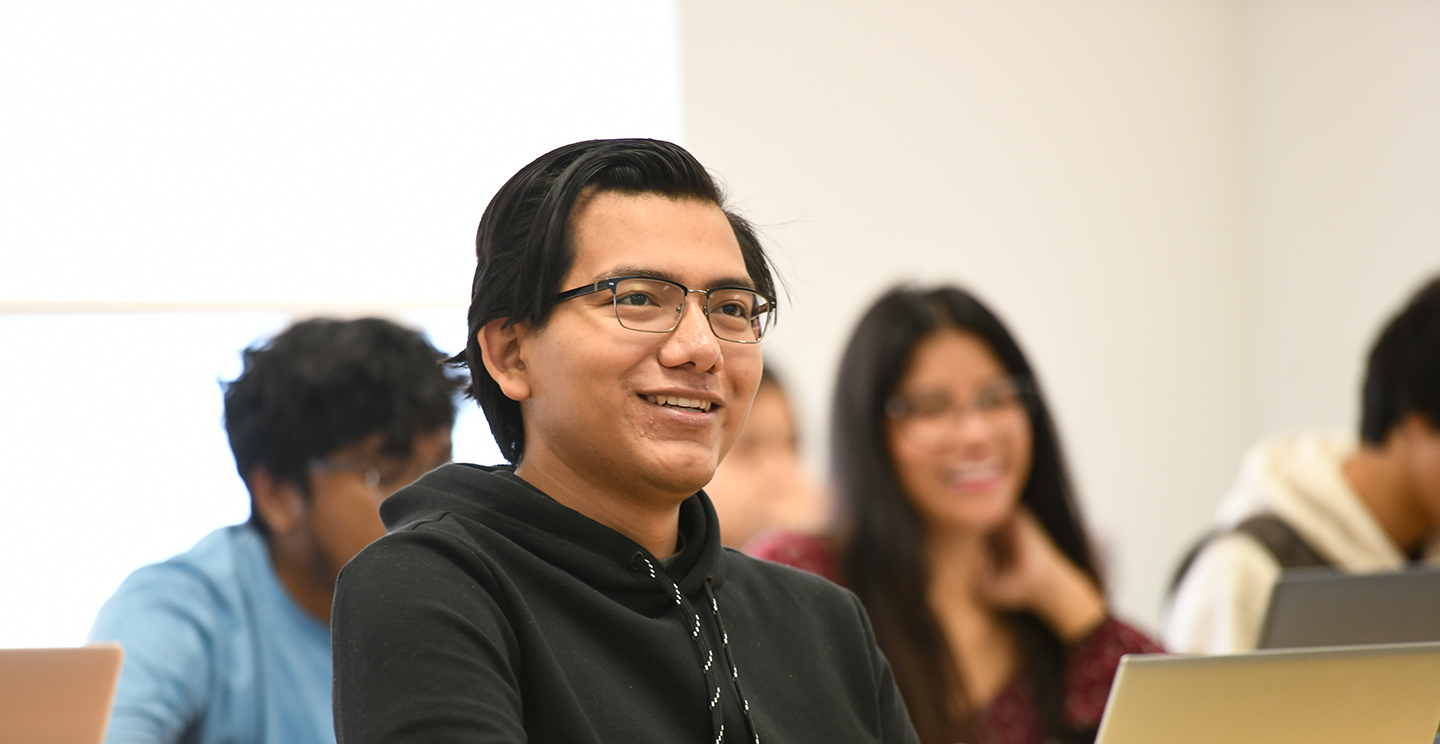 Student in a classroom with a laptop.